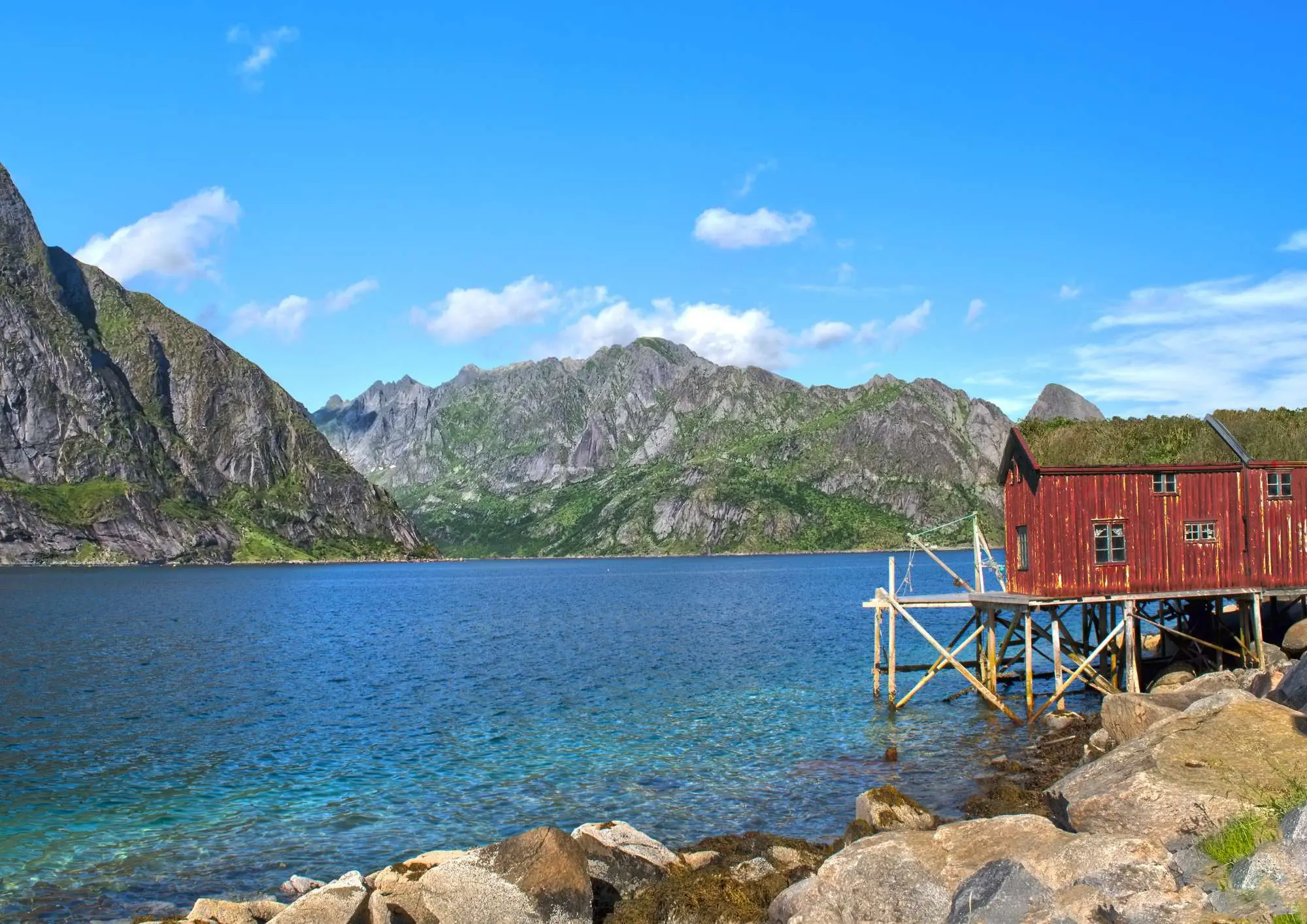 red rorbu cabin on stilts in Lofoten fjord
